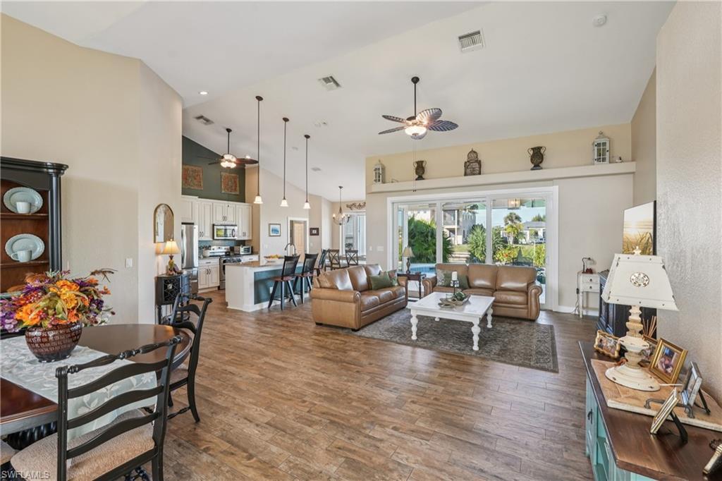 Image 4: Living room with a ceiling fan, high vaulted ceiling, dark wood finished floors, and recessed lighting