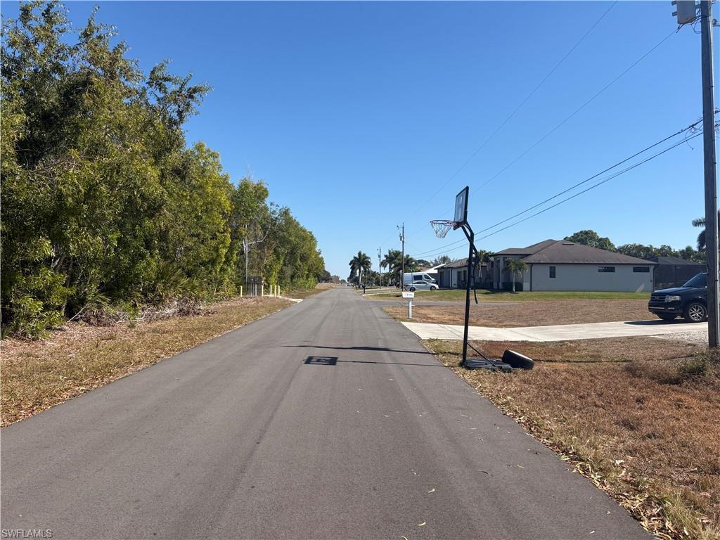 Image 2: View of asphalt street with a residential view