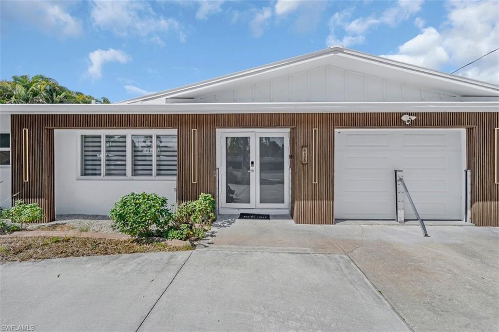 Image 2: View of front facade with french doors and a garage