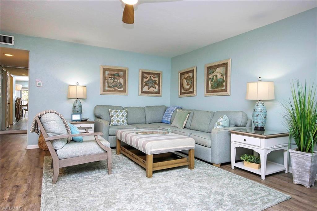 Image 4: Living room with wood finished floors, a ceiling fan, visible vents, and baseboards
