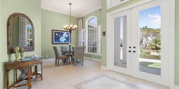 Image 4: Dining room with light tile patterned flooring, ornamental molding, hanging lights, french doors, and inlaid floor details