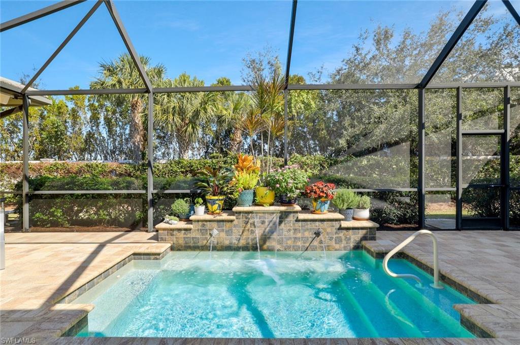 Image 3: Huge Spa with Water Feature Graces the outdoor living with Outdoor Kitchen and Gorgeous Flowers in Pots to enhance the Lanai