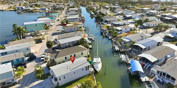 Image 2: Aerial view of property and surrounding area featuring a large body of water and nearby suburban area