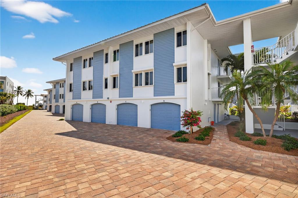 Image 3: View of apartment building / complex featuring driveway and a garage