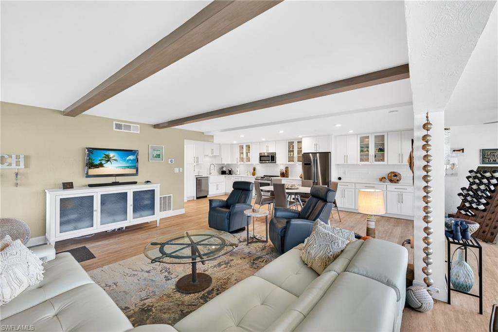 Image 4: Living room featuring beamed ceiling, light wood-style floors, and recessed lighting