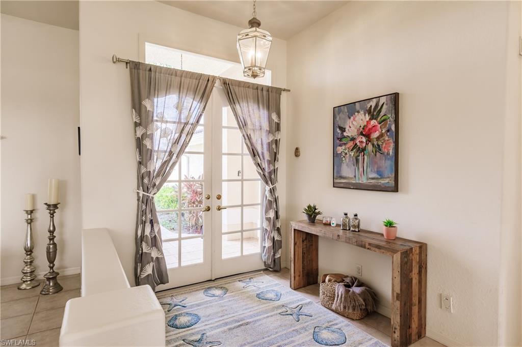 Image 3: Doorway to outside featuring french doors and light tile patterned flooring