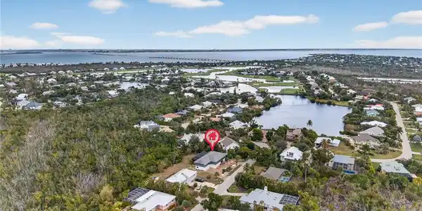 Image 2: Aerial perspective of suburban area with a nearby body of water