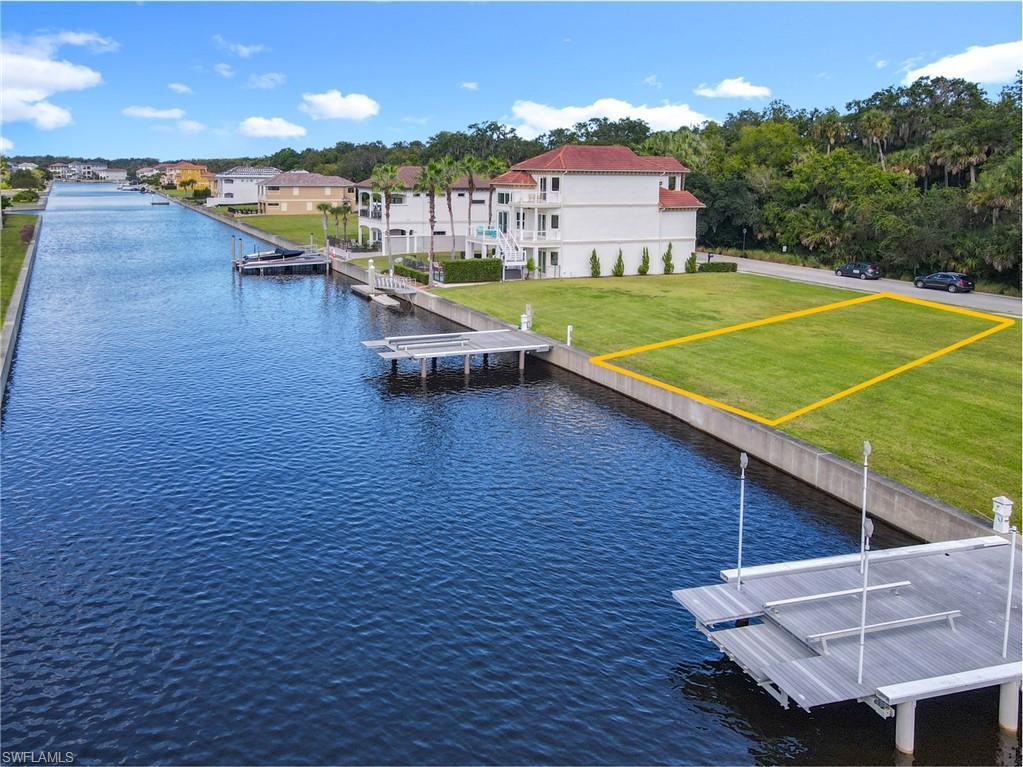 Image 3: Dock featuring a lawn and a water view