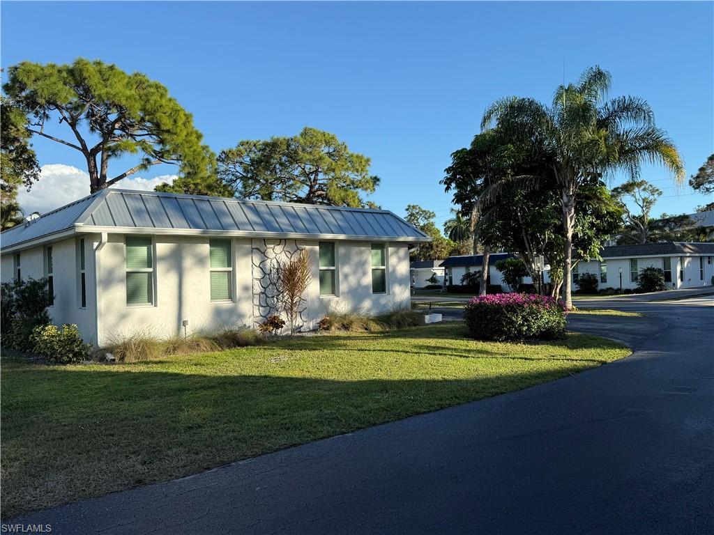 Image 1: Ranch-style house featuring a metal roof, a front lawn, stucco siding, and a standing seam roof