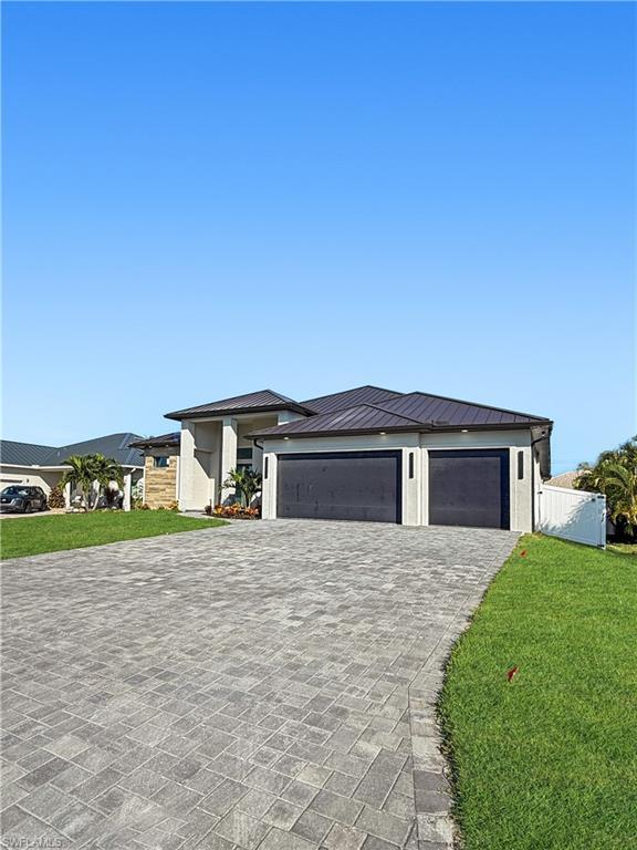 Image 3: Prairie-style house with a front yard, decorative driveway, an attached garage, and a metal roof