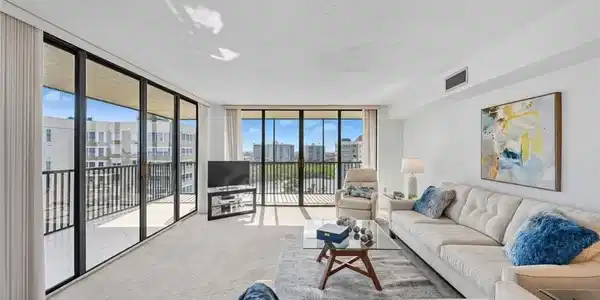 Image 3: Carpeted living area featuring expansive windows and a textured ceiling