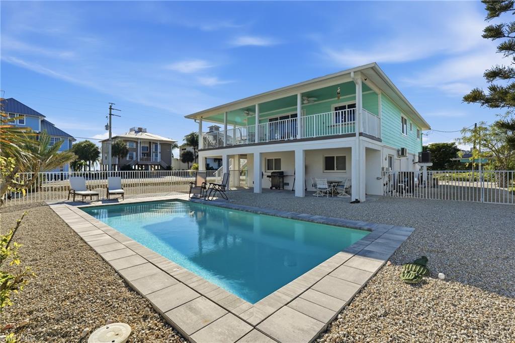 Image 1: Rear view of property with a patio, a fenced backyard, and a ceiling fan - Virtually Edited Image