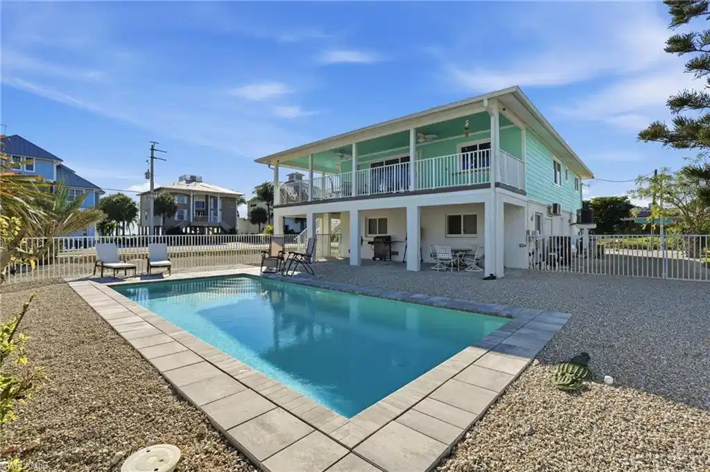 Image 1: Rear view of property with a patio, a fenced backyard, and a ceiling fan - Virtually Edited Image
