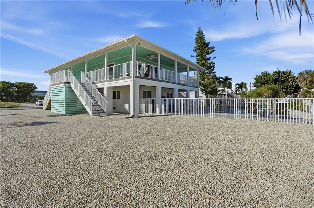 Image 3: Rear view of property with ceiling fan, stairway, and covered porch - Virtually Edited Image
