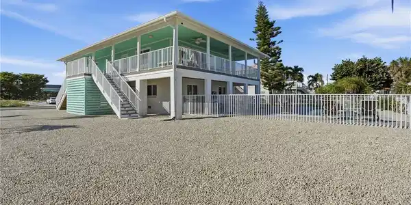 Image 3: Rear view of property with ceiling fan, stairway, and covered porch - Virtually Edited Image