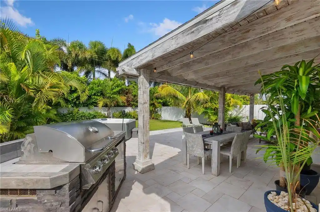 Image 1: Fenced backyard featuring outdoor dining space, a patio, and exterior kitchen