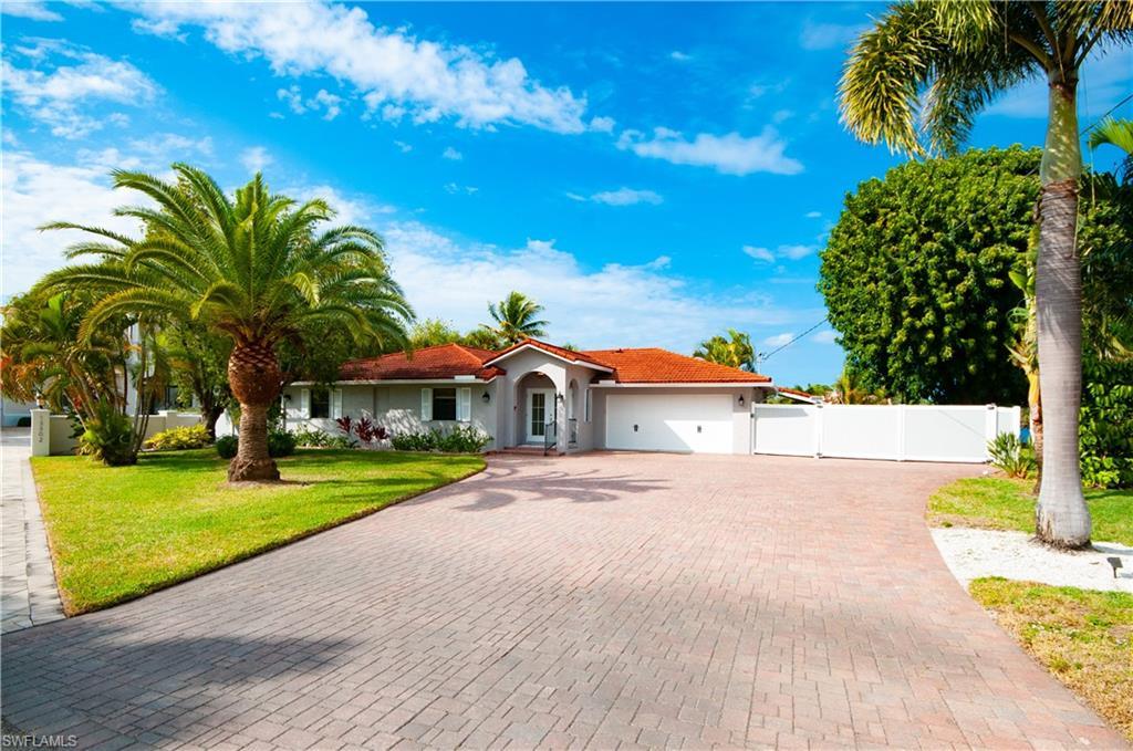Image 2: Mediterranean / spanish-style house with an attached garage, decorative driveway, stucco siding, and a gate