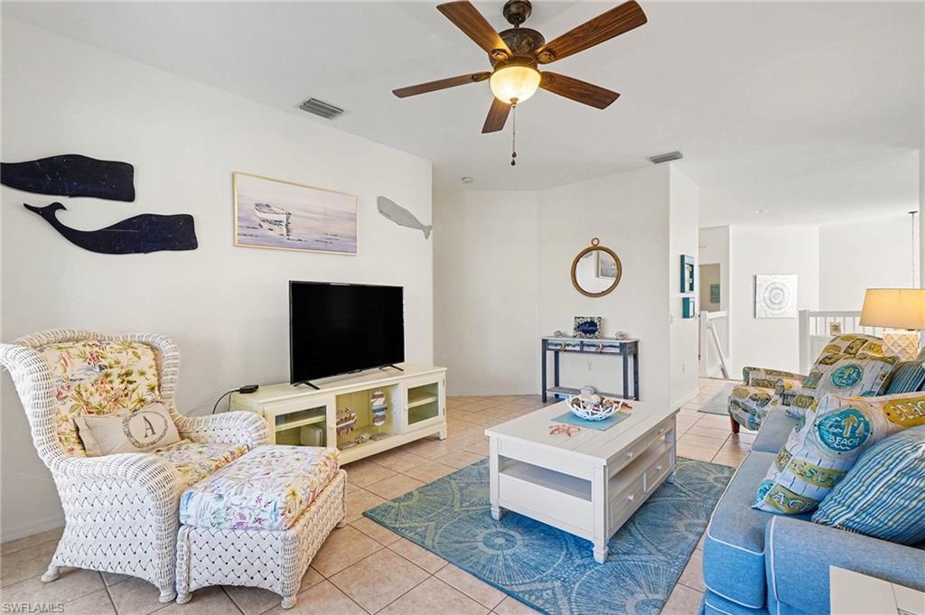 Image 3: Living area with ceiling fan and tile patterned flooring