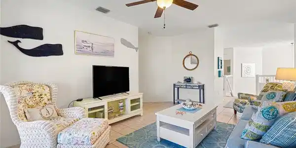 Image 3: Living area with ceiling fan and tile patterned flooring