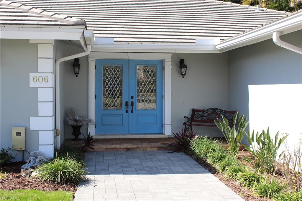 Image 2: Doorway to property with french doors, a tile roof, and stucco siding