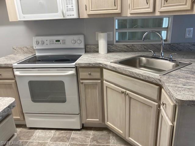 Image 3: Kitchen featuring white appliances, light brown cabinets, and light countertops
