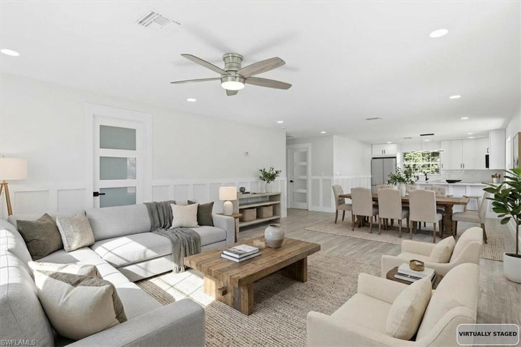 Image 2: Living room with light wood-type flooring, -ceiling fan, a decorative wall, recessed lighting, and a wainscoted wall Virtualy stage