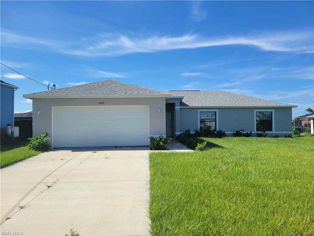 Image 1: Ranch-style home featuring a front yard and a garage