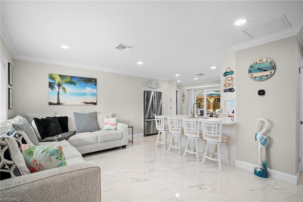 Image 3: Living room featuring crown molding, light marble finish floors, and recessed lighting