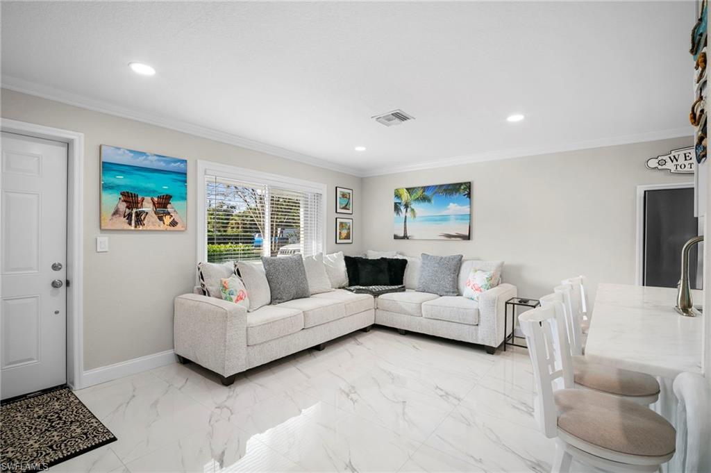 Image 4: Living room with ornamental molding, light marble finish flooring, and recessed lighting