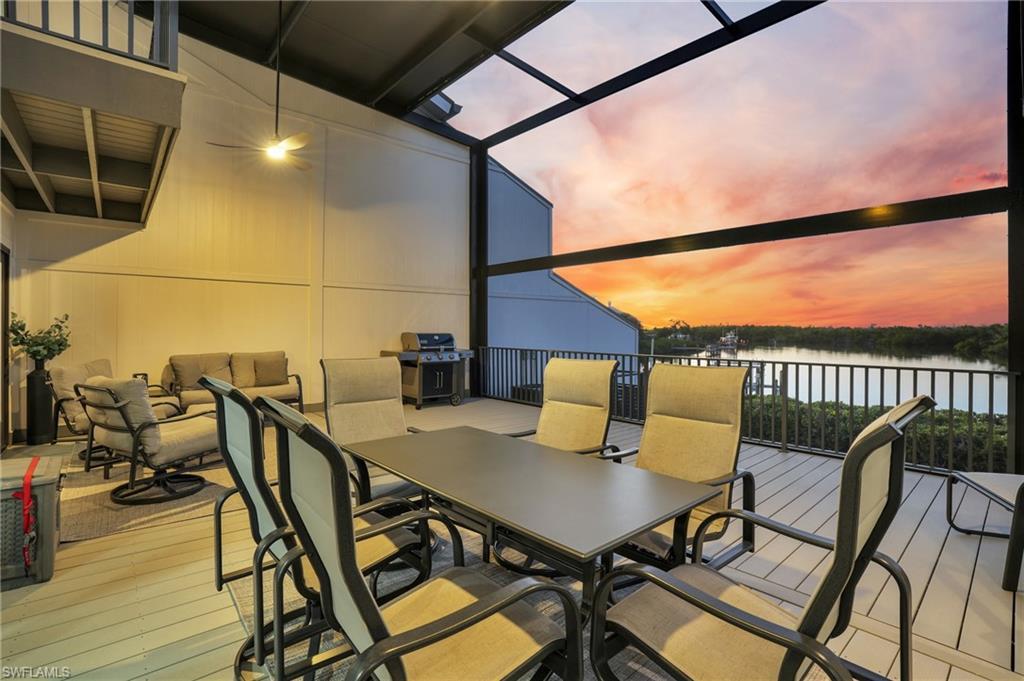 Image 3: Wooden deck featuring outdoor dining area, glass enclosure, area for grilling, a sunroom, and a water view
