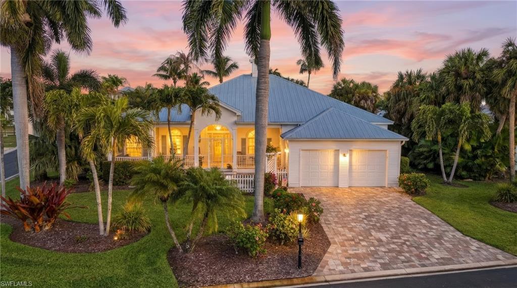 Image 1: View of front of home featuring a metal roof, driveway, a front yard, and a garage