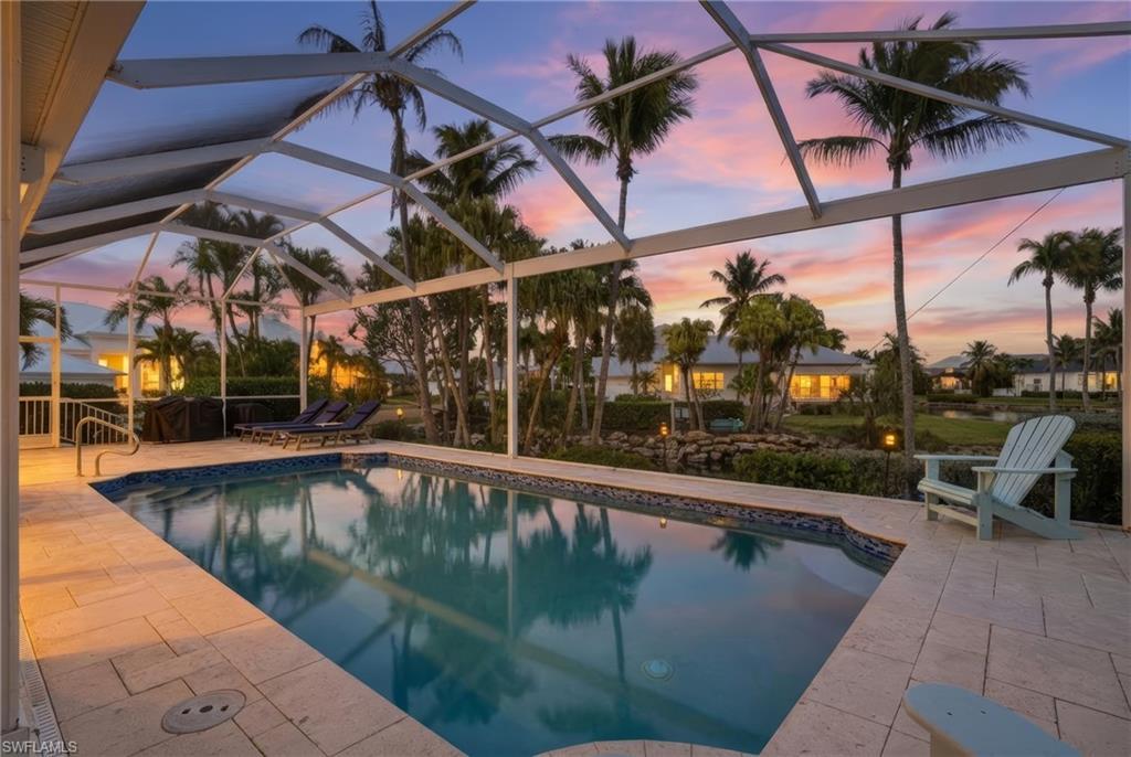 Image 2: Pool at dusk featuring an outdoor pool, glass enclosure, and a sunroom