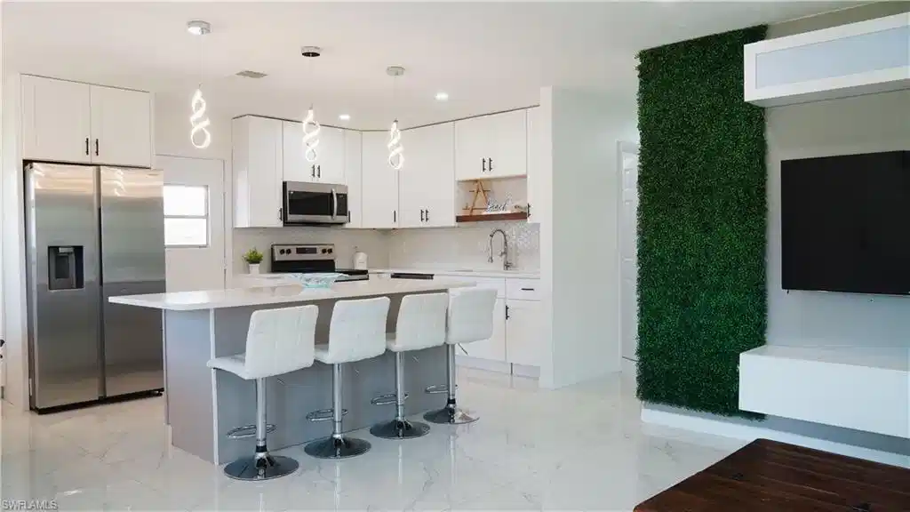 Image 1: Two tone kitchen with stainless steel appliances, pendant lighting, a kitchen island, a breakfast bar area, and open shelves