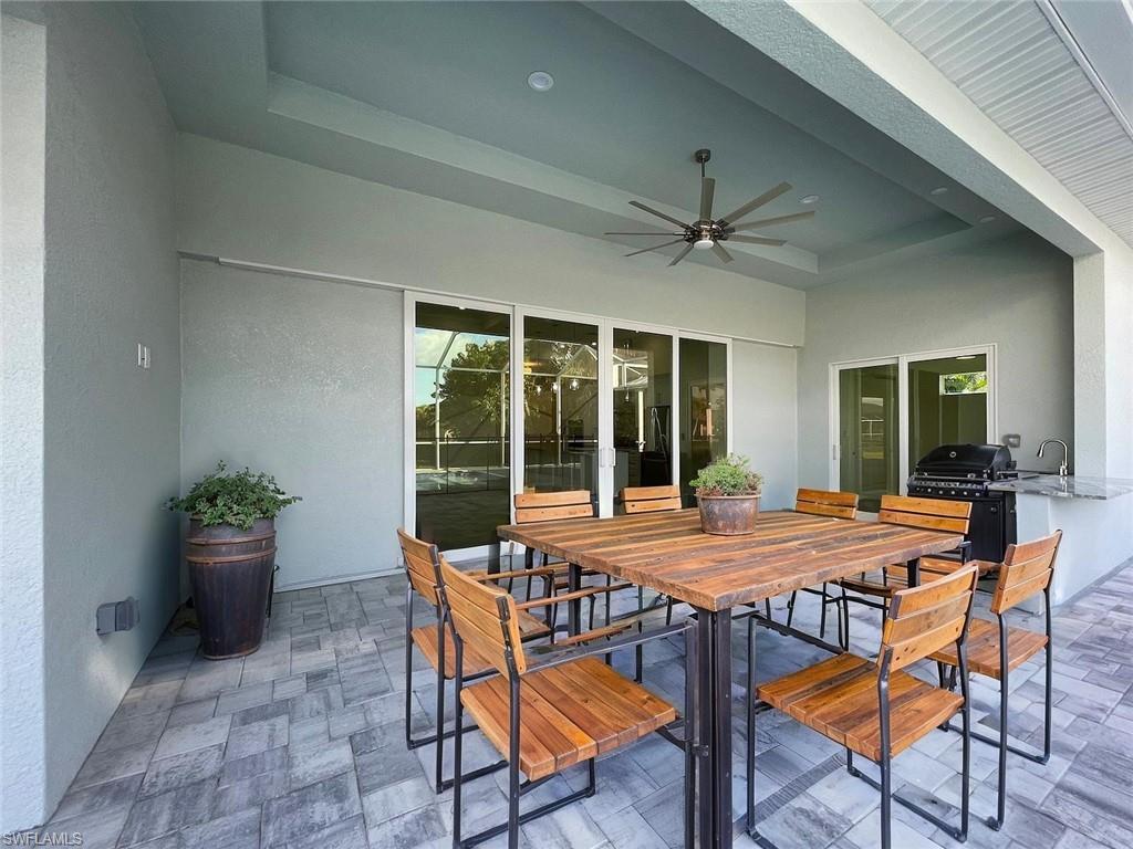 Image 3: View of patio with exterior kitchen, a ceiling fan, and outdoor dining space