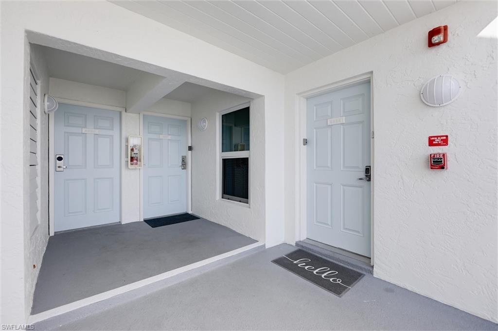 Image 2: View of exterior entry with a porch and stucco siding