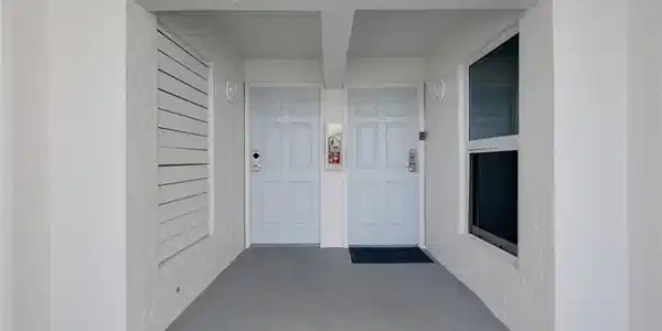 Image 3: Entrance to property with covered porch and stucco siding