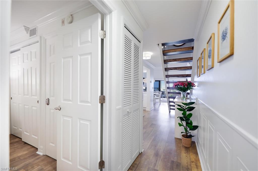 Image 4: Corridor featuring crown molding, dark wood-style flooring, and a decorative wall