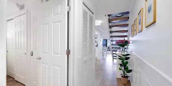 Image 4: Corridor featuring crown molding, dark wood-style flooring, and a decorative wall
