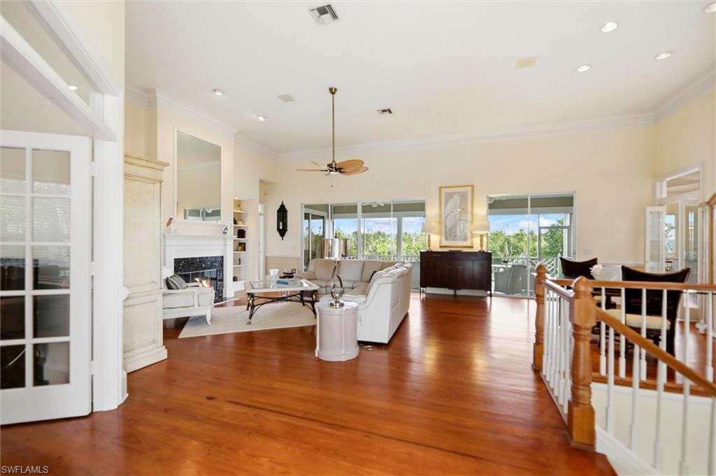 Image 3: Living room featuring a fireplace, plenty of natural light, ceiling fan, wood finished floors, and ornamental molding
