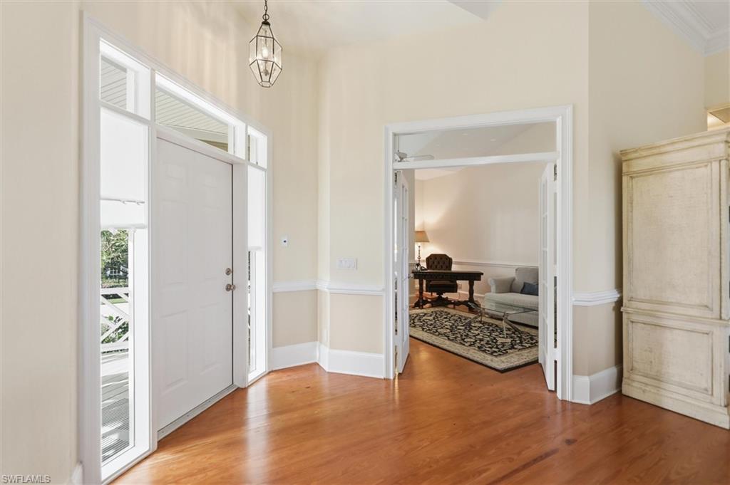 Image 4: Foyer with wood finished floors and hanging lights