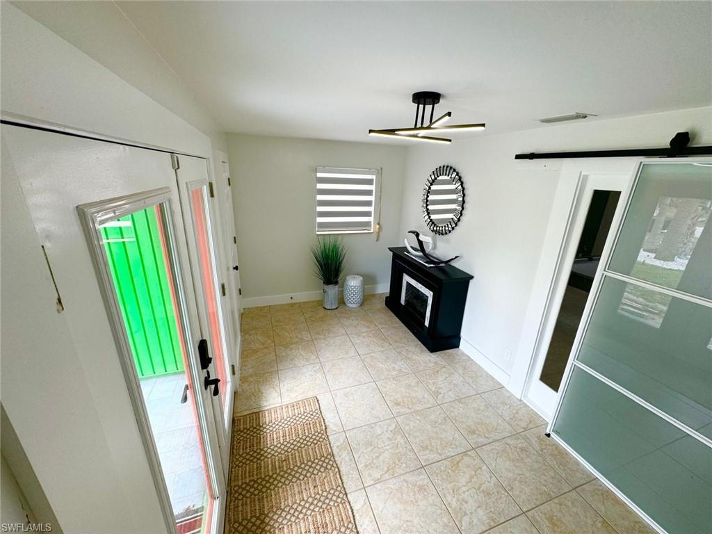 Image 3: Foyer featuring light tile patterned flooring and baseboards