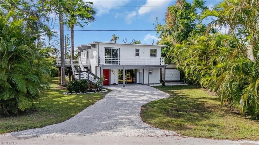 Image 1: View of front facade with a garage, a front lawn, and a carport