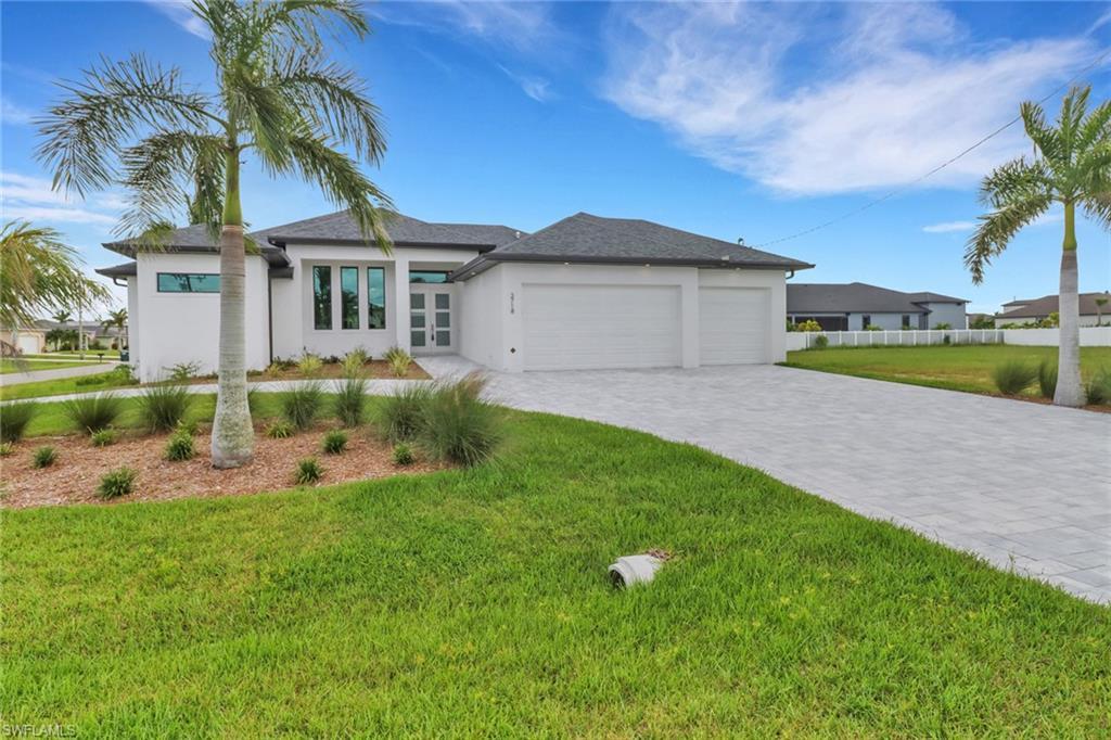 Image 1: Prairie-style house featuring an attached garage, stucco siding, and decorative driveway
