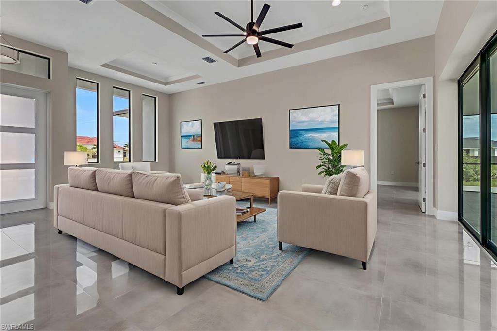 Image 2: Living room featuring a tray ceiling and ceiling fan