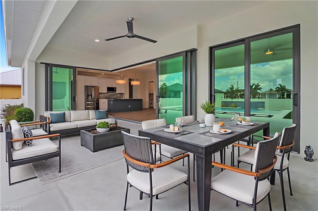 Image 3: View of patio / terrace featuring outdoor dining space, an outdoor hangout area, and ceiling fan