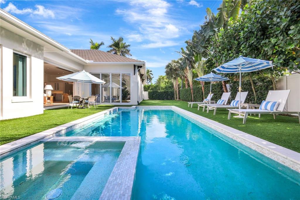 Image 4: View of pool with a patio area, a pool with connected hot tub, and a sunroom
