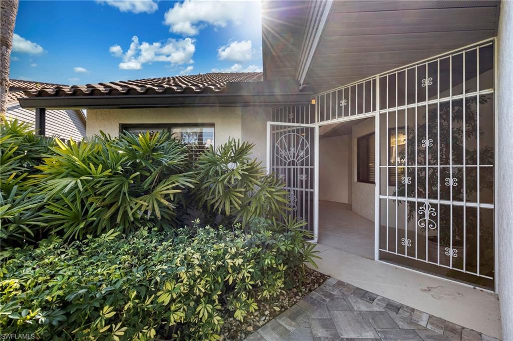 Image 3: Doorway to property featuring stucco siding and a tiled roof