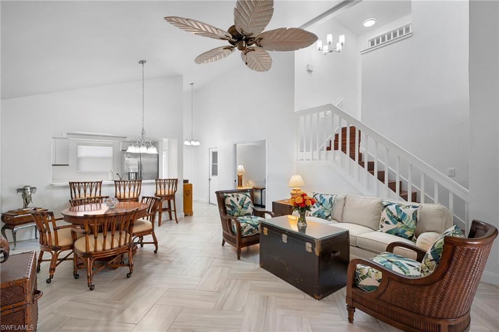 Image 2: Living area with hanging lights, a ceiling fan, parquet floors, and vaulted ceiling