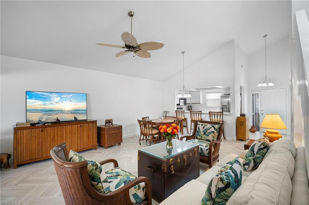Image 4: Living room with suspended lighting, ceiling fan, parquet flooring, and lofted ceiling