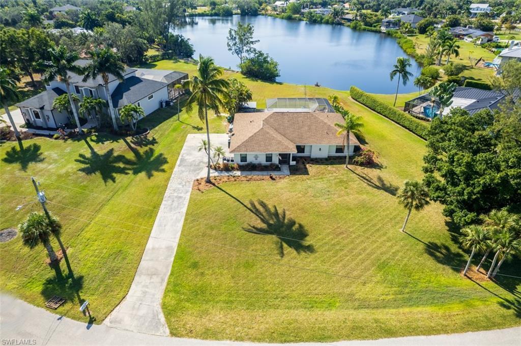 Image 1: Aerial view of property and surrounding area featuring a nearby body of water and a tree filled landscape
